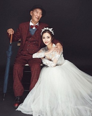 صور شابة صينية ترتدي فستان زفاف لالتقاط صور بصحبة جدها المسن