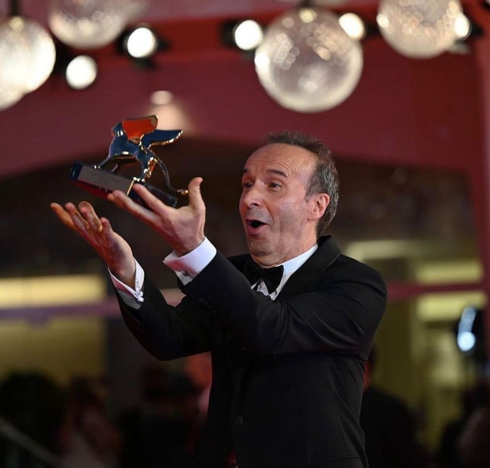 الممثل الإيطالي روبرتو بينيني يرفع جائزة الأسد الذهبي في الهواء