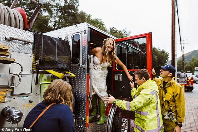 العروس و هي تنزل من شاحنة الاطفاء بمساعدة رجال الاطفاء لدى وصولها مكان حفل زفافها