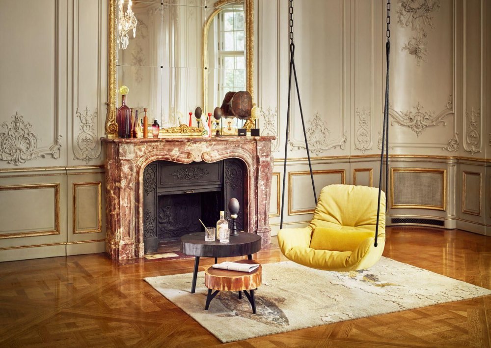 الكرسي المعلق بلونه الأصفر يبرز ضمن ديكور المنزل الفخم