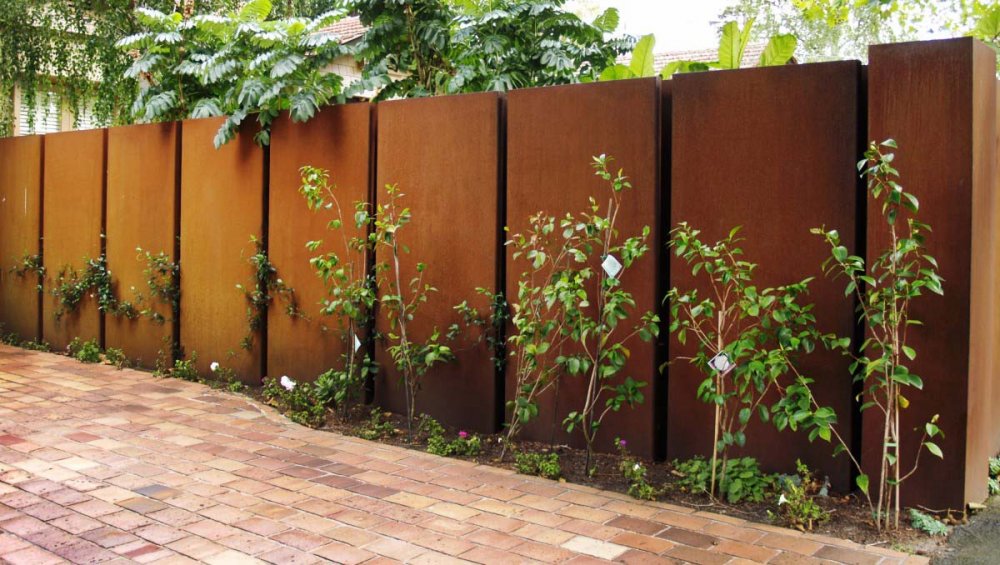 ‎تصميم سياج فيللا من الخشب محاط بشريط من النباتات الخضراء لمظهر جذاب