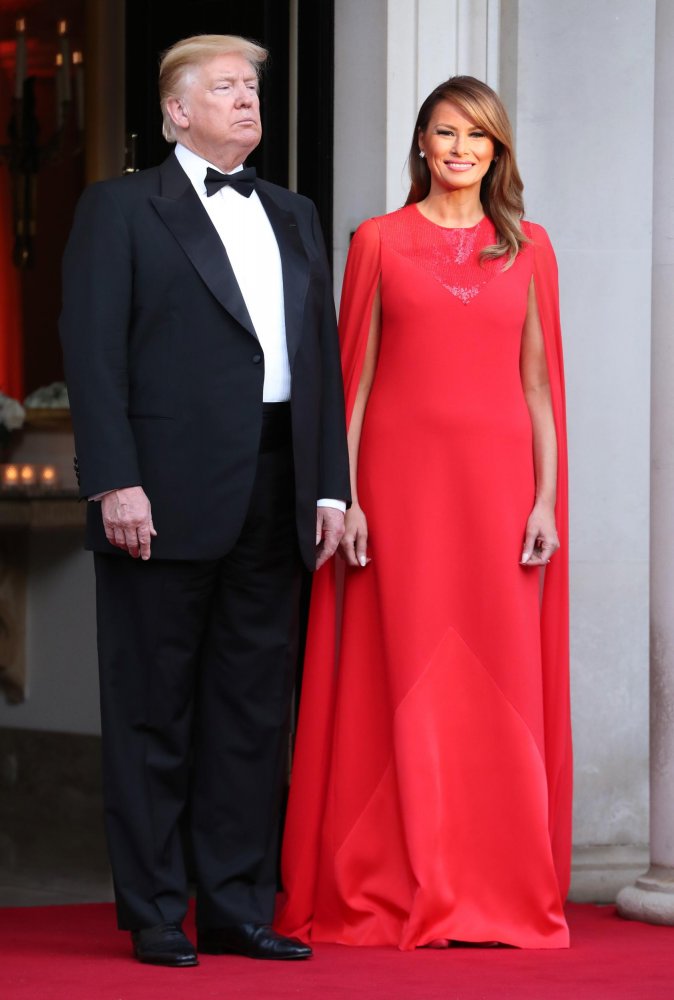 ميلانيا ترامب بموضة الفستان الأحمر الطويل مع قصة الأكمام المنسدلة عن الأكتاف على شكل كاب من Givenchy