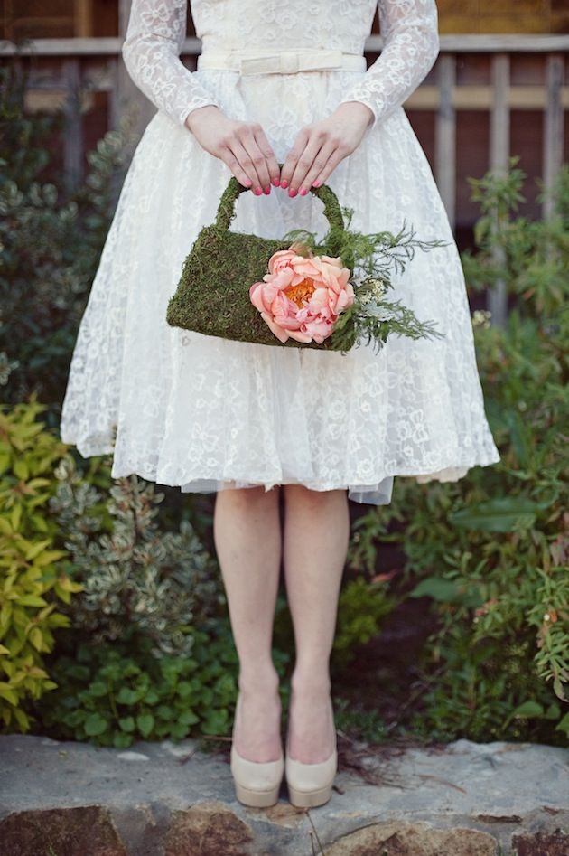 حقيبة عروس أنيقة مزينة بنباتات الزينة الخضراء والزهور الملونة