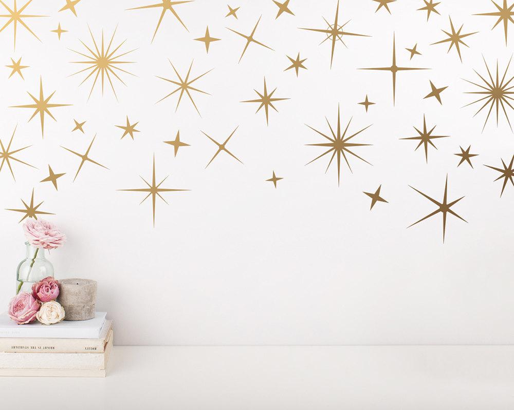 ‎⁨تصاميم نجوم متنوعة تزيين جدار غرفة النوم ببريقها الذهبي