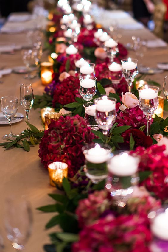  الشموع و الورود باللون البرغندي في وسط طاولات الزفاف