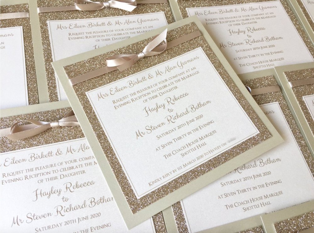 بطاقة دعوة لحفل زفاف مستوحى من الأجواء الملكية ذات لون أبيض ناصع البياض مع لمسات من اللون الذهبي