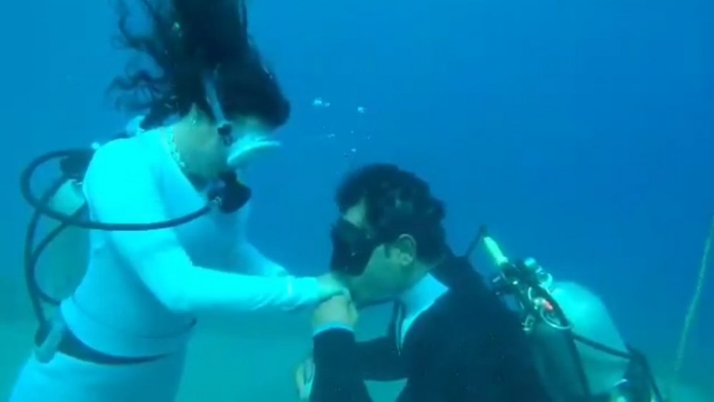 الخطيب صدام الكيلاني و هو ممس بيد خطيبته يطلب يدها في مشهد رومانسي في أعماق البحر