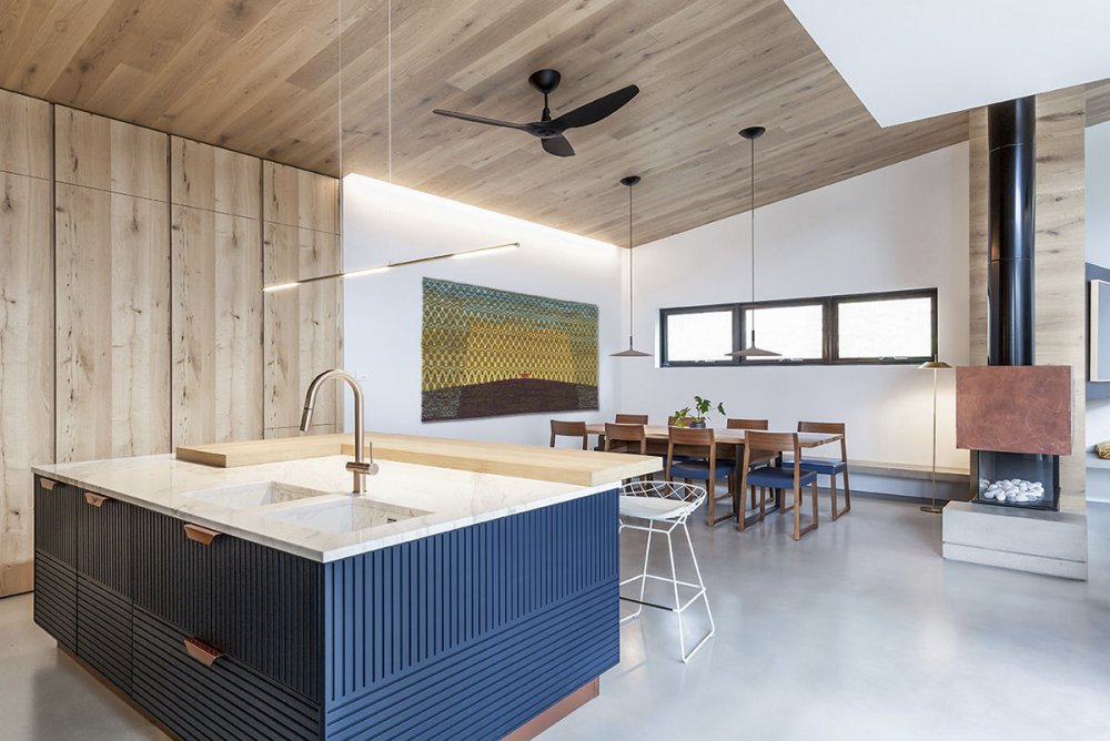 ديكور مطبخ خشبي يتميز بجزيرة المطبخ بلونها الأزرق وتصميمها العصري