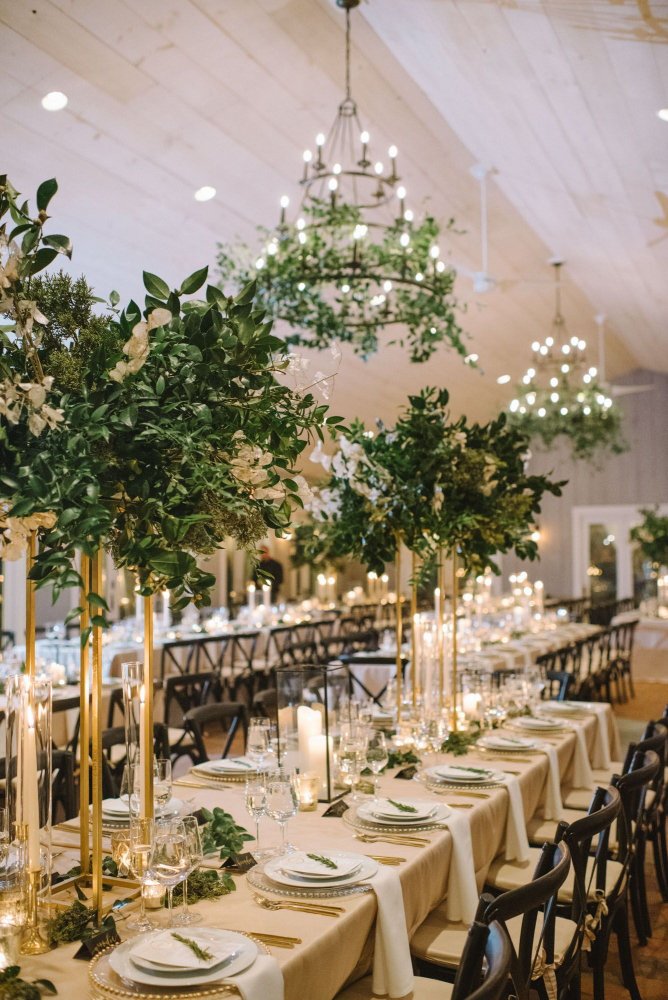 زيني طاولات حفل زفافك بمفارش قماشية خضراء أنيقة ومزهريات كريستالية ضخمة تزينها