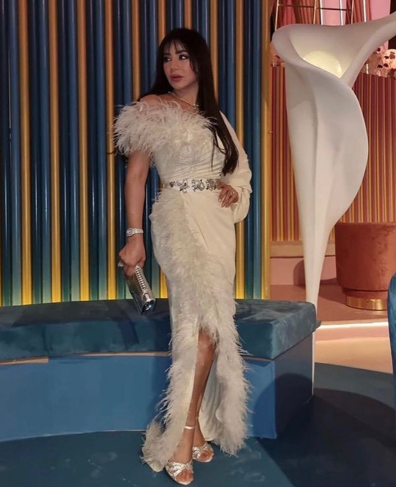 اطلالة الإعلامية لجين عمران بموضة الفستان الأبيض مع تفاصيل الريش الجانبية