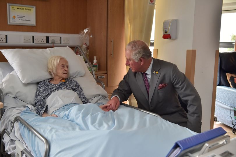 الأمير تشارلز يمسك بيد مريضة مسنة أصيبت من جراء الفيضانات في إقليم ويلز