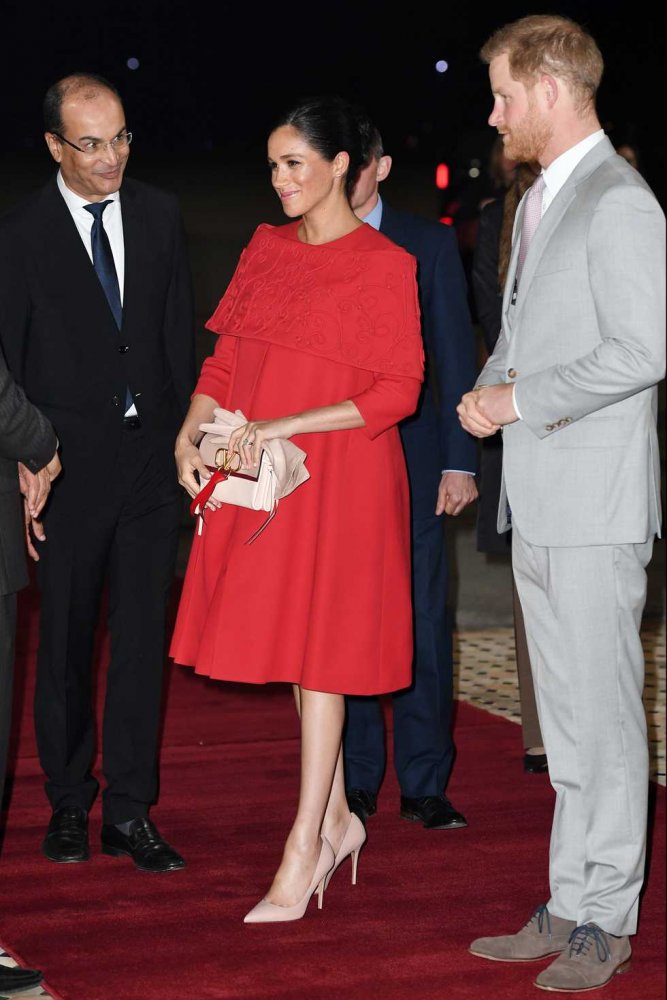 ميغان ماركل Meghan Markle بفستان أحمر واسع مع قصة الأكتاف الطويلة من فالنتينو Valentino