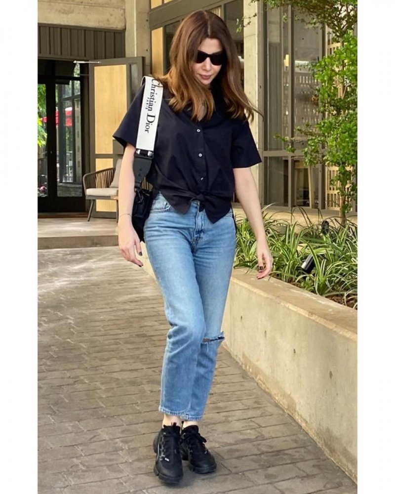 اطلالة جينز كاجوال نسقتها نانسي مع قميص اسود واسع ذو اكمام قصيرة