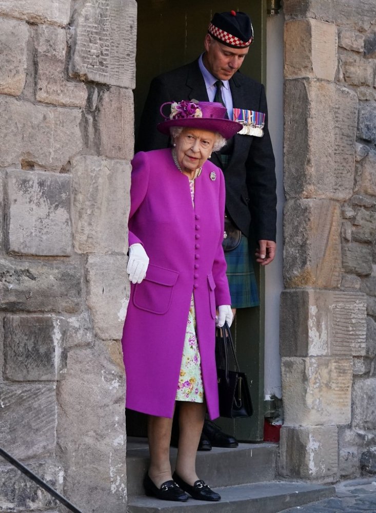اطلالة الملكة اليزابيث بالمعطف البنفسجي والفستان المورد الصورة من AFP